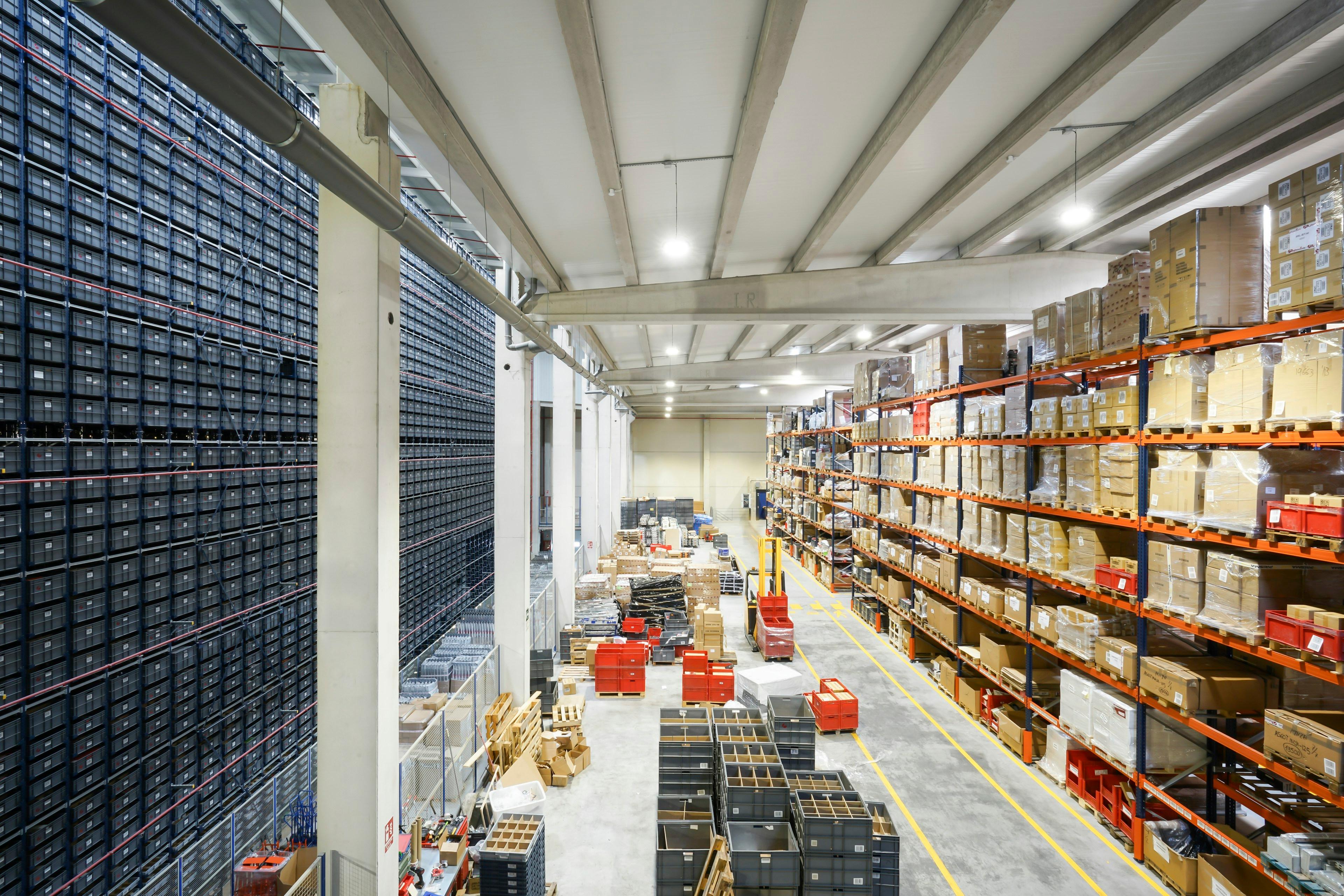 A modern fulfillment floor with storage racks, packed inventory, and a wide working aisle